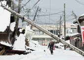 Suzu. Unas personas caminan bajo líneas eléctricas caídas en esta ciudad japonesa, afectada por el terremoto del 1 de enero de 2024.