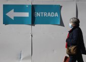 Una mujer con mascarilla camina en el entorno de un centro de salud en Madrid este 8 de enero de 2024, día en el que el Ministerio de Sanidad ha pedido a las comunidades que implanten el uso obligatorio de la mascarilla en centros sanitarios y sociosanitarios.