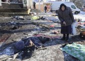 Una mujer camina entre los cuerpos de las víctimas del bombardeo del mercado de alimentos de Donetsk, Ucrania, este 21 de Enero.