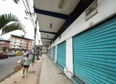 Comercio. Un ciudadano camina por la acera de una calle principal de Quevedo, junto a una serie de locales que permanecen cerrados, por alquilar o vender.