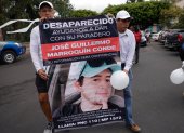 Familiares de Guillermo Marroquín muestran hoy un cartel con su retrato durante una marcha.