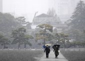 Unas personas caminan durante las nevadas en los jardines que rodean el Palacio Imperial en Tokio, Japón, el 5 de febrero de 2024.