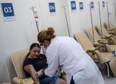 Una trabajadora de la salud revisa a una paciente sospechosa de dengue hoy, en el Centro de Atención de Dengue de la Policlínica Rodolpho Rocco, en el barrio Del Castilho, en Río de Janeiro (Brasil).