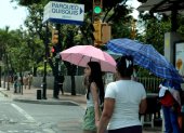 Temperatura. Ciudadanos se protegen del sol con sombrillas.