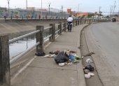 Varios ciudadanos colocan fundas con desechos junto a un canal entre las ciudadelas Las Orquídeas y Los Vergeles.