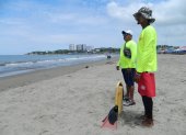 Dos salvavidas vigilan a los escasos bañistas en un sector de la playa de General Villamil.