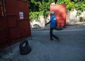 Un hombre cruza una barrera a la entrada de un barrio, este domingo en Puerto Príncipe (Haití).
