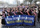 Los médicos portan una pancarta mientras marchan hacia la oficina presidencial en el distrito de Yongsan, Seúl, Corea del Sur, el 25 de febrero de 2024.