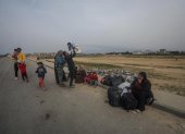 Un grupo de palestinos descansa tras cruzar desde el norte de la Franja de Gaza hacia el sur por la carretera Al Rashid, el 26 de febrero de 2024.