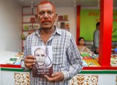 Shahjahan Bhuiyan, con un ejemplar de su libro "Cómo fue la vida del verdugo", en la caseta de la editorial Kingbondonti durante la feria anual del libro en Dacca, Bangladesh.