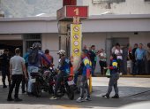 Varias personas hacen fila para abastecerse de combustible