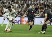 El delantero brasileño del Real Madrid Vinicius Jr. (i) se escapa con el balón de los jugadores de Manchester City