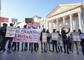 Integrantes de entidades sociales impulsoras de la iniciativa legislativa popular se manifiestan durante el debate en el pleno del Congreso de los Diputados, en Madrid.
