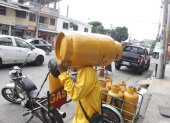 Guayaquil. Una persona que trabaja llevando tanques de gas camina al domicilio de uno de sus clientes.