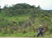 José Jiménez, de 81 años, posa delante del bosque que desde hace quince años protege, en San Andrés, Zamora Chinchipe.