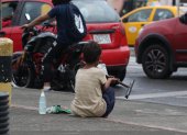 Un menor en edad escolar se dedica a limpiar parabrisas en una calle del centro de Guayaquil.