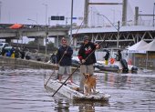 Dos hombres utilizan unas tejas para navegar en una zona inundada el 16 de mayo de 2024, en el municipio de Canoas, estado de Rio Grande do Sul (Brasil).