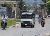 Motociclistas transitan junto a un carro blindado de la Policía Nacional Haitiana, para poder pasar por la zona cercana al Palacio Nacional, donde son habituales los enfrentamientos con las bandas armadas, este sábado, en Puerto Príncipe (Haití). La Policía Nacional Haitiana emitió hoy sus condolencias a la familia de los ciudadanos estadounidenses asesinados por pandilleros y aseguró que identificará y apresará los culpables de los crímenes. EFE/ Orlando Barría