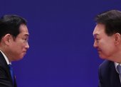 El presidente surcoreano, Yoon Suk Yeol (i), le da la mano al primer ministro japonés, Fumio Kishida, en la conferencia de prensa conjunta al margen de la Cumbre Trilateral.