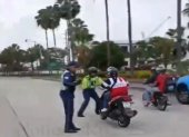 Momento en el que el agente intentó, sin suerte, de detener al motociclista.
