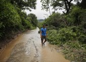 Un hombre camina por un sendero inundado debido a fuertes lluvias, el 21 de junio del 2024, en Soyapango.