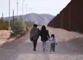 Una familia camina a lo largo del muro fronterizo de Estados Unidos buscando a la Patrulla Fronteriza estadounidense para entregarse para su procesamiento en Lukeville, Arizona, Estados Unidos.