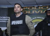 Un agente de la Dirección de Análisis Criminal e Inteligencia (DACI) de Bolivia escolta al capitán de infantería Miguel Burgos este 28 de junio de 2024, durante su presentación luego de su arresto en La Paz (Bolivia).