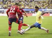El delantero brasileño Vinicius Junior (d) intenta pasar por el defensor costarricense Haxzel Quiros (i) y el centrocampista costarricense Alejandro Bran (C) durante la segunda mitad de la CONMEBOL.