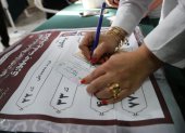 Una mujer iraní rellena la papeleta de voto en un colegio electoral durante las elecciones presidenciales, en Teherán, Irán, el 28 de junio de 2024.