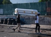 Puerto Príncipe. Dos hombres cargan ataúd por una calle de esta capital.