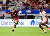 José Salomón Rondón (Izq.) de Venezuela anota el gol del empate 1-1 contra Moise Lumpungu (Der.) de Canadá durante la segunda mitad de la Copa América 2024.