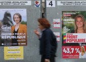 Una mujer pasa por un cartel de los candidatos (R) del Nouveau Front Populaire "el Nuevo frente Popular" para las elecciones parlamentarias en París, Francia, 04 de julio de 2024. La segunda vuelta del Las elecciones parlamentarias francesas se celebrarán el 7 de julio de 2024. (Elecciones, Fran