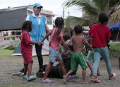 Una funcionaria de Aldeas Infantiles pinta la mano de una niña el 8 de julio de 2024 en Turbo.