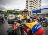 Un hombre en motocicleta recorre una calle durante una protesta por los resultados de las elecciones presidenciales este lunes, en Caracas (Venezuela).