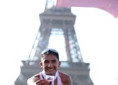 El marchista ecuatoriano no perdió la oportunidad de mostrar la foto de sus hijos Nico y Monse, tras ganar la medalla de oro al pie de la Torre Eiffel.