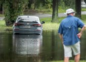 Un automóvil quedó atascado en una calle inundada tras una lluvia.