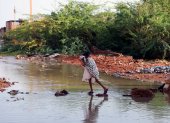 Una persona intenta atravesar una zona rural inundada en este país africano.
