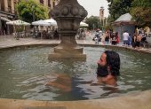Granada. Un hombre se refresca en una fuente de la Plaza Nueva.