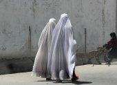 Mujeres afganas vestidas con burka caminan por una carretera en Kandahar.