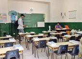 Una profesora prepara clase en el salón de una escuela previo al inicio de clases