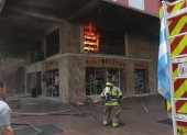 Un bombero intenta sofocar las llamas del interior de un establecimiento en las calles Boyacá y Clemente Ballén, en el centro de Guayaquil.