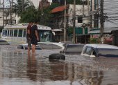 Hombres tailandeses observan una calle inundada tras fuertes lluvias en zonas urbanas de la provincia de Chiang Rai, al norte de Tailandia, el 12 de septiembre de 2024.