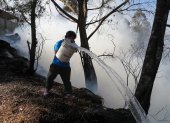 Quito. Una persona trata de apagar el fuego en un bosque.
