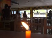 En las mesas de un restaurante se colocaron velas por la falta de luz. La afluencia de clientes disminuyó en comparación con un día normal.