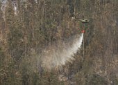 Helicópteros militares realizan descargas de agua en focos de fuego que se reactivaron en el cerro Auqui, nororiente de Quito, este miércoles 25 de septiembre.