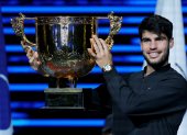 El español Carlos Alcaraz celebra con el trofeo tras vencer en la final del Open de China de Tenis al italiano Jannik Sinner.
