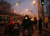 En la imagen de archivo, peatones utilizan mascarillas para protegerse de la contaminación en Pekín (China).