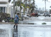 Una mujer camina por una calle inundada tras el paso del huracán Milton en Bradenton, Florida.