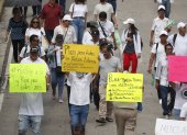 Manifestantes sostienen carteles en una marcha este sábado 19 de octubre en San Salvador (El Salvador).