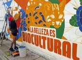 Una mujer pinta un mural este sábado 19 de octubre en Cali. La ciudad colombiana levantará este domingo el telón de la cumbre COP16.